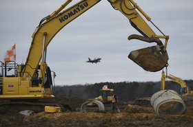 Aspen Construction workers move a segment of cement pipe on the airfield construction site at Joint Base Langley-Eustis, Virginia,