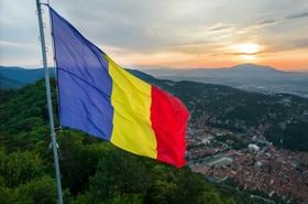 Romanian flag on the top of the hill in Brasov at sunset
